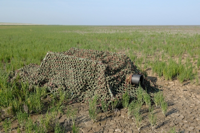 Een foto van mijn camouflagenet over frame. Het lijkt hier wat groter dan het is. De hoogte is variabel al naar gelang hoe diep je de poten in de grond drukt. Gemiddeld zo rond de 50cm hoog.