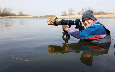 Henk met waadpak om futen te fotografen.

Zit hier op een campingstoeltjes. Statief staat in het water met daarop camera plus lens.